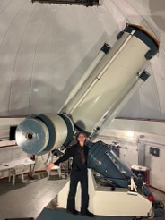 Alexis, standing in front of a large telescope
