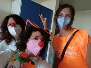 Grace with two health professionals wearing medical masks and clown noses