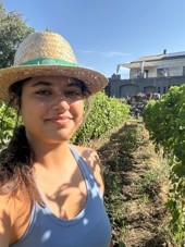Mia standing in a vineyard